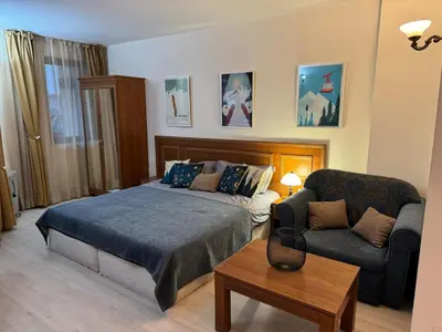 a bedroom with a bed and a couch and a chair at Emerald Apartment - complex Bansko in Bansko