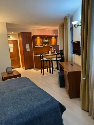 a hotel room with a bed and a dining room at Emerald Apartment - complex Bansko in Bansko