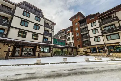 a group of buildings with snow on the street at Emerald Apartment - complex Bansko in Bansko