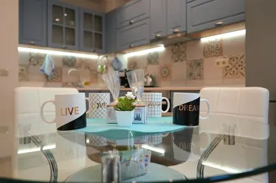 a glass table in a kitchen with two mugs on it at Cozy Apartment in the Heart of Sofia, BG in Sofia