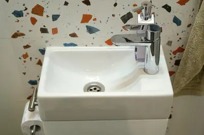 a white sink with a faucet in a bathroom at Cozy Apartment in the Heart of Sofia, BG in Sofia