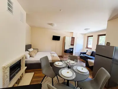 a room with a bed and a living room at Студио Алтом in Pamporovo
