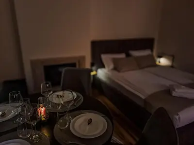 a room with a bed and a table with wine glasses at Студио Алтом in Pamporovo
