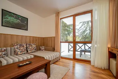 a living room with a couch and a window at ЕлеаНора, Смолянски езера EleaNora Smolyan lakes in Smolyan