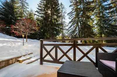 a snow covered deck with a wooden fence and benches at ЕлеаНора, Смолянски езера EleaNora Smolyan lakes in Smolyan