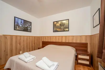 a bedroom with a bed with two white towels at ЕлеаНора, Смолянски езера EleaNora Smolyan lakes in Smolyan