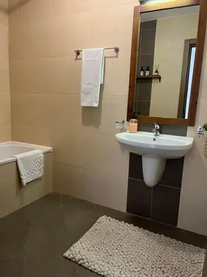 a bathroom with a sink and a tub and a mirror at Daliya's Apartment in Bansko