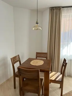 a dining room with a wooden table and chairs at Daliya's Apartment in Bansko