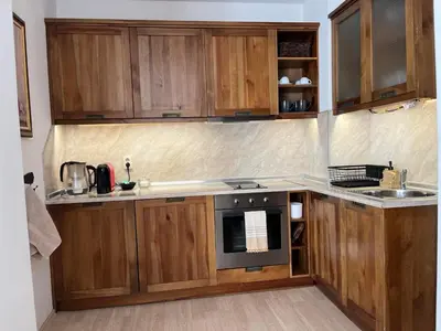 a kitchen with wooden cabinets and a stove top oven at Daliya's Apartment in Bansko