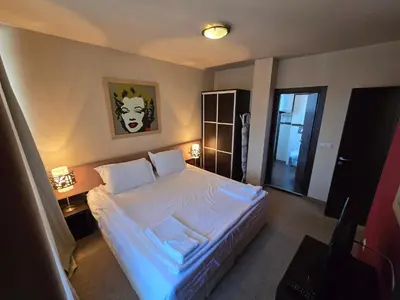 a bedroom with a large white bed with two pillows at Bansko Apartment Next To The Ski Lift in Bansko