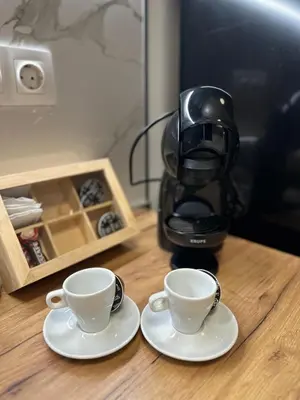two coffee cups on a table next to a coffee maker at Delux 2 - Plovdiv Модерен апартамент до Стария град и Източната порта in Plovdiv