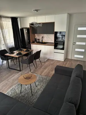 a living room with a couch and a table and a kitchen at Infinity Park Apartment in Sandanski