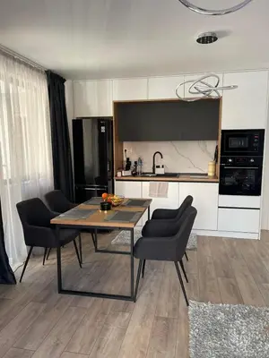 a kitchen and dining room with a table and chairs at Infinity Park Apartment in Sandanski