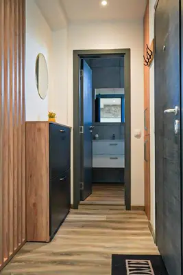 a hallway with a bathroom with a sink and a mirror at Апартамент за Гости Танчеви in Karlovo