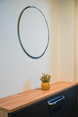 a mirror above a dresser with a vase of flowers at Апартамент за Гости Танчеви in Karlovo