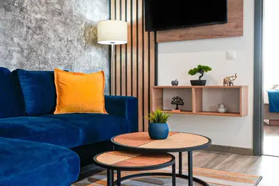 a living room with a blue couch and a table at Апартамент за Гости Танчеви in Karlovo