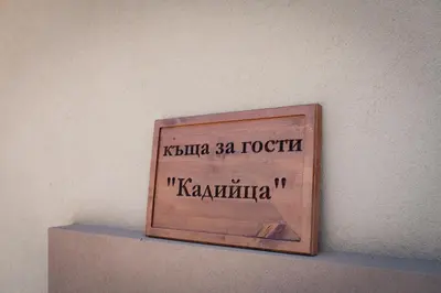 a wooden sign on a shelf on a wall at Къща за гости 'Кадийца' in Sushitsa