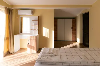 a bedroom with a large bed and a window at Къща за гости 'Кадийца' in Sushitsa