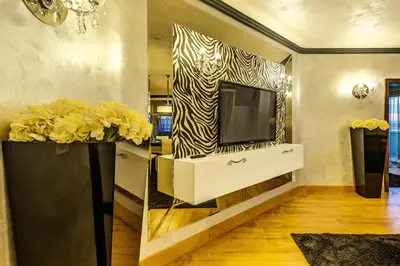 a living room with a tv and a zebra print wall at Capital City Center Apart Residence in Plovdiv
