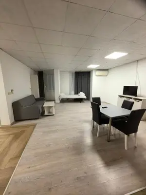 an empty room with a table and chairs and a couch at Apartament Bellisimo in Sofia