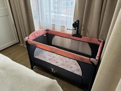 a baby crib in a bedroom next to a window at Guest Apartment Elina in Smolyan