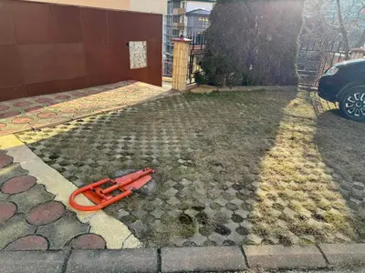 a red hose laying on the side of a driveway at Guest Apartment Elina in Smolyan