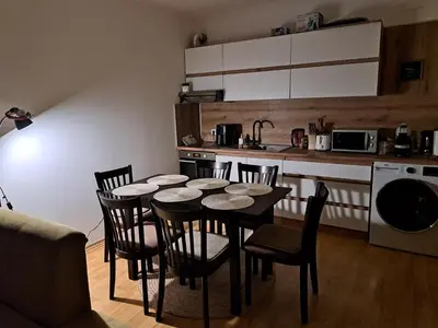 a kitchen with a table and chairs in a room at Sun and view cozy apartment in Razlog