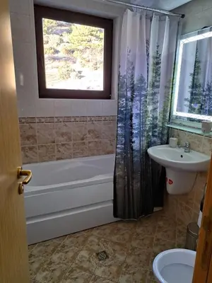 a bathroom with a tub and a toilet and a sink at Sun and view cozy apartment in Razlog