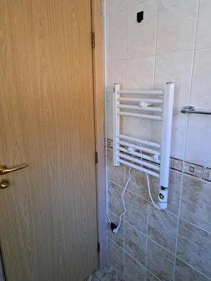 a door to a bathroom with a heater on the wall at Sun and view cozy apartment in Razlog