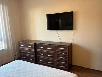 a bedroom with a dresser with a tv on the wall at Green life Bansko -view one bedroom apartment in Bansko