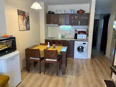 a kitchen with a table and chairs in a kitchen at Green life Bansko -view one bedroom apartment in Bansko