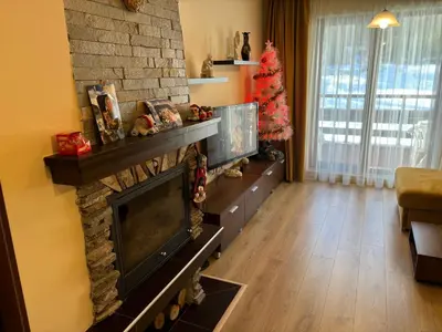 a living room with a fireplace and a christmas tree at Green life Bansko -view one bedroom apartment in Bansko