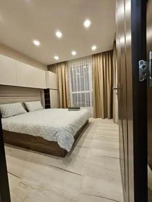 a bedroom with a bed and a large window at Boutique apartment green 2 in Plovdiv