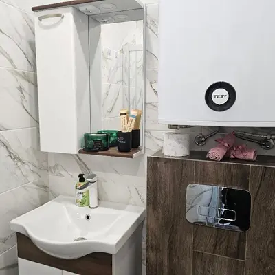 a bathroom with a white sink and a mirror at Boutique apartment green 2 in Plovdiv