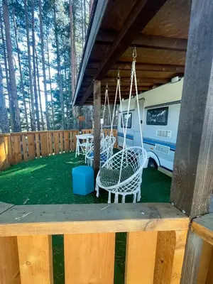 a porch with a swing and an rv at Къмпинг Alino Lake in Alino