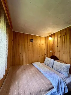 a bedroom with a bed in a wood paneled room at Вила Рози, Семково in Semkovo