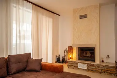 a living room with a couch and a fireplace at Holiday home with indoor fireplace in Pamporovo