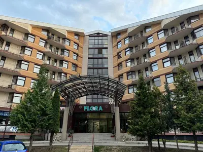 a large apartment building with an arch in front of it at SnowLine Flora in Borovets