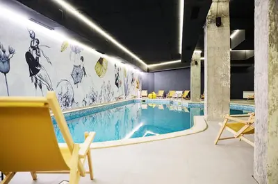a swimming pool with yellow chairs and a swimming pool at SnowLine Flora in Borovets