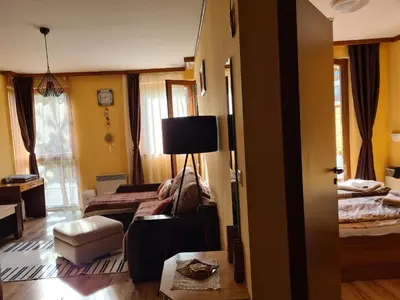 a living room with a couch and a bed at Zweizimmerwohnung mit Bergblick in Bansko
