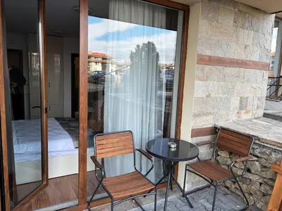 a balcony with a table and two chairs and a bed at Divine mountain studio - parking - SPA in Bansko