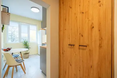 a wooden door in a kitchen with a table and chair at Lotus apartments with free parking in Sofia