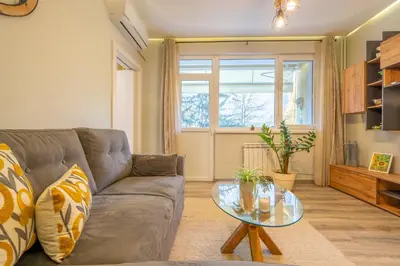 a living room with a couch and a glass table at Lotus apartments with free parking in Sofia