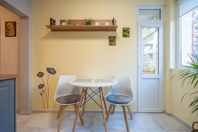 a dining room with a table and two chairs at Lotus apartments with free parking in Sofia