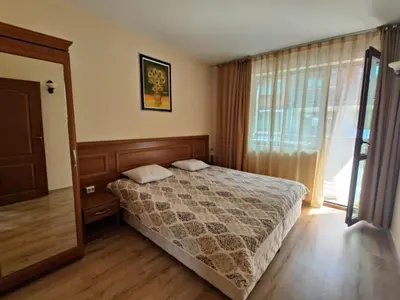 a bedroom with a bed and a large window at Fenix Emerald in Bansko