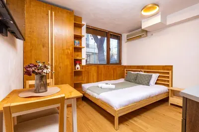 a small bedroom with a bed and a table at The Crash Pad Studio by Flat Mаnager in Plovdiv