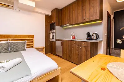 a bedroom with a large bed and a kitchen at The Crash Pad Studio by Flat Mаnager in Plovdiv