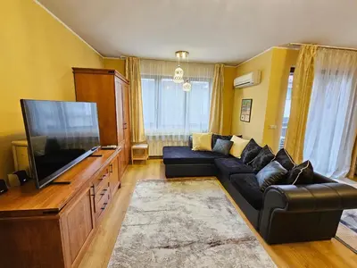 a living room with a couch and a flat screen tv at Two charming Studios in Trinity Bansko with balcony and free parking by Flat Mаnager in Bansko