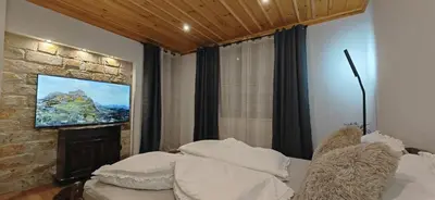 a bedroom with a bed and a tv on a wall at Rhodopski Apartment in Chepelare