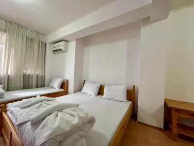 a small bedroom with two beds and a window at Вила Стряма in Hisarya